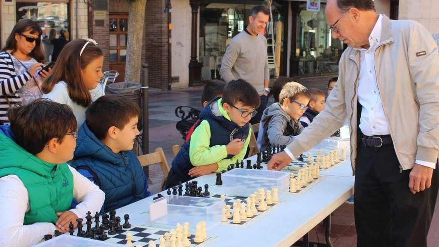 El presidente y director de la Escuela de Ajedrez en una partida simultánea con pequeños.