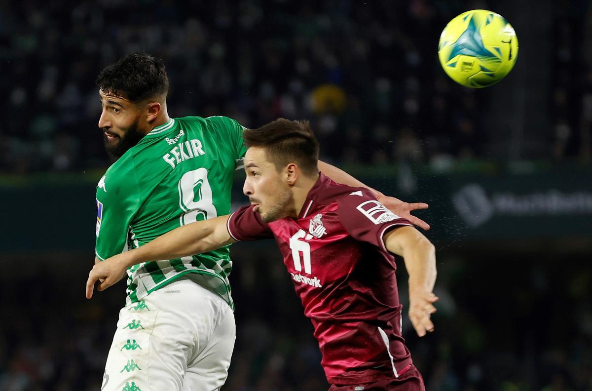 El centrocampista francés del Real Betis Nabil Fekir (i) remata de cabeza durante el partido correspondiente a la jornada 17 de LaLiga Santander que juegan Real Betis y Real Sociedad hoy domingo en el estadio Benito Villamarín.