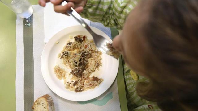 Una niña comiendo en un colegio de la ciudad.