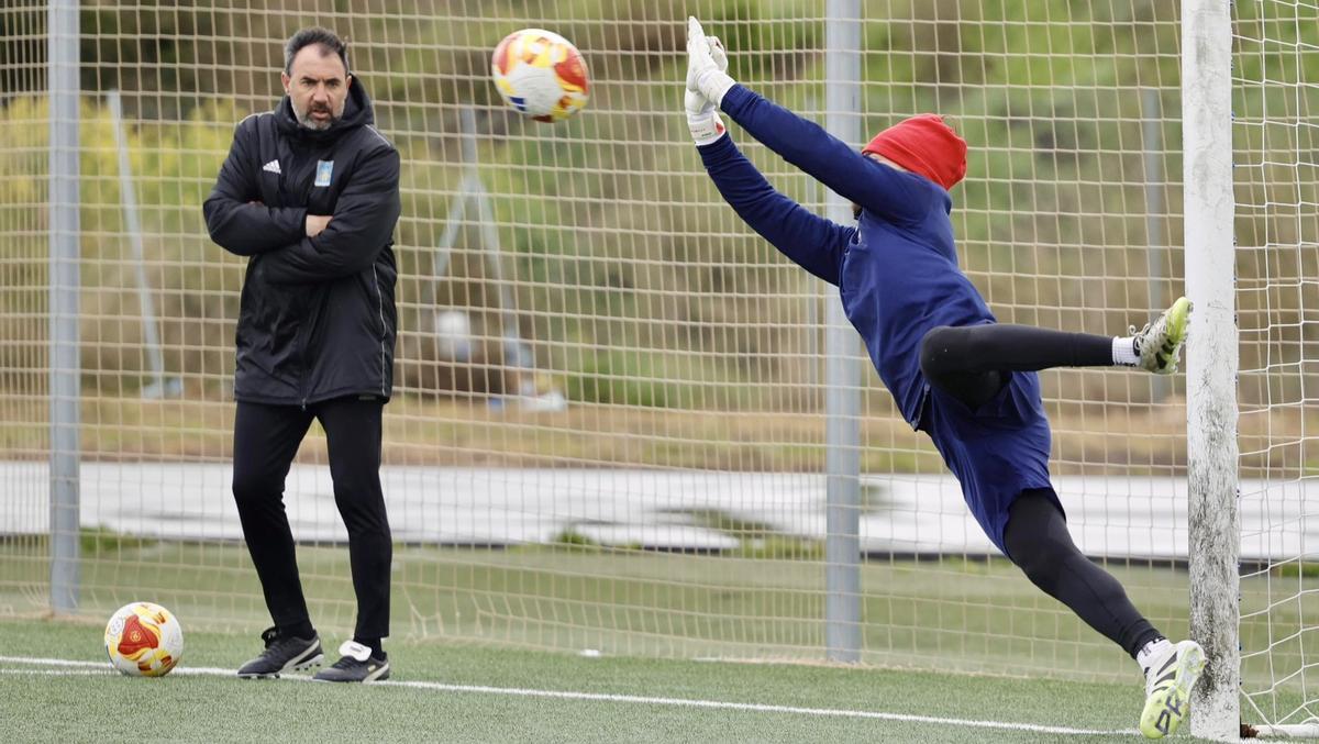 El meta realiza un parada en un entrenamiento junto al técnico, Juanma Barrero.