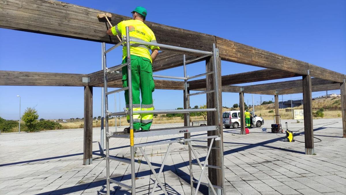 Los operarios protegen la pérgola de la humedad y de los insectos xilófagos.