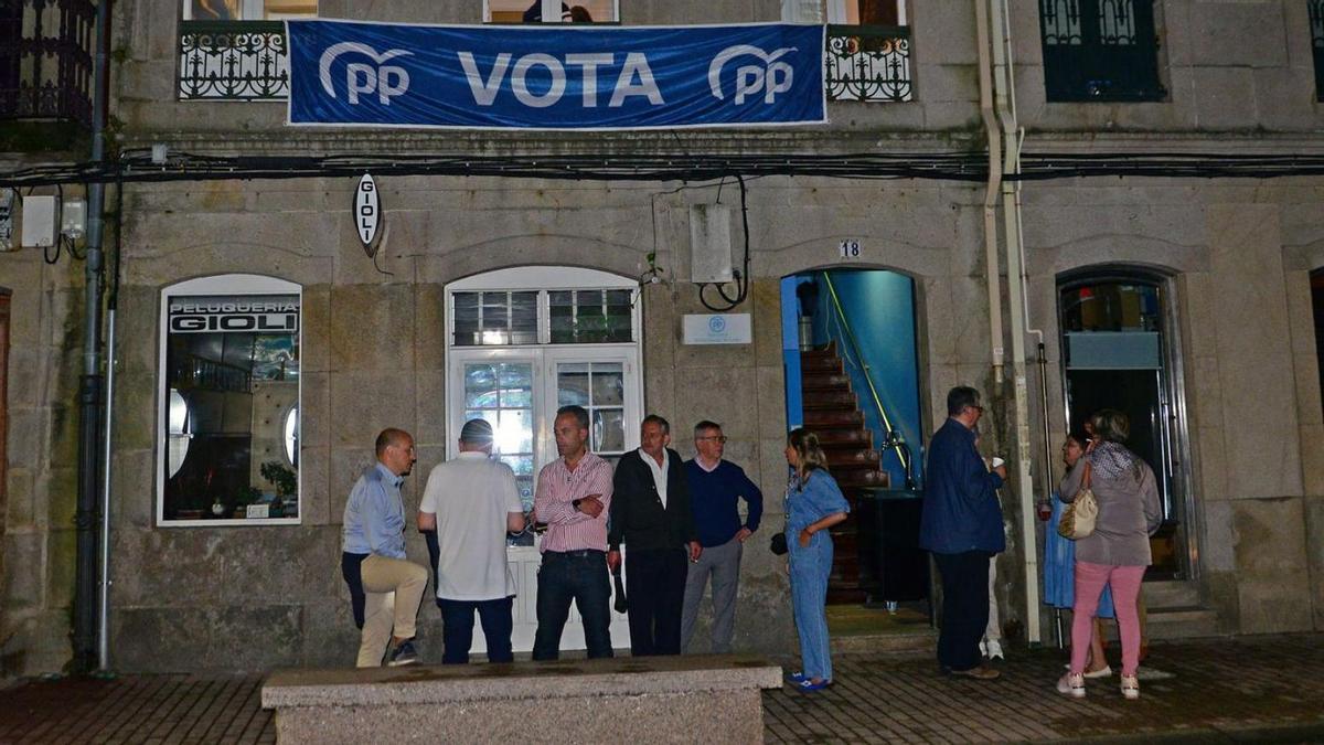 Candidatos y simpatizantes del PP, con gesto abatido, ayer por la noche frente a su sede. |  // G.NÚÑEZ