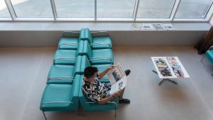 Un usuario lee la prensa en el interior de la biblioteca Canyadó i Casagemes-Joan Argenté de Badalona, uno de los nuevos refugios climáticos de la ciudad