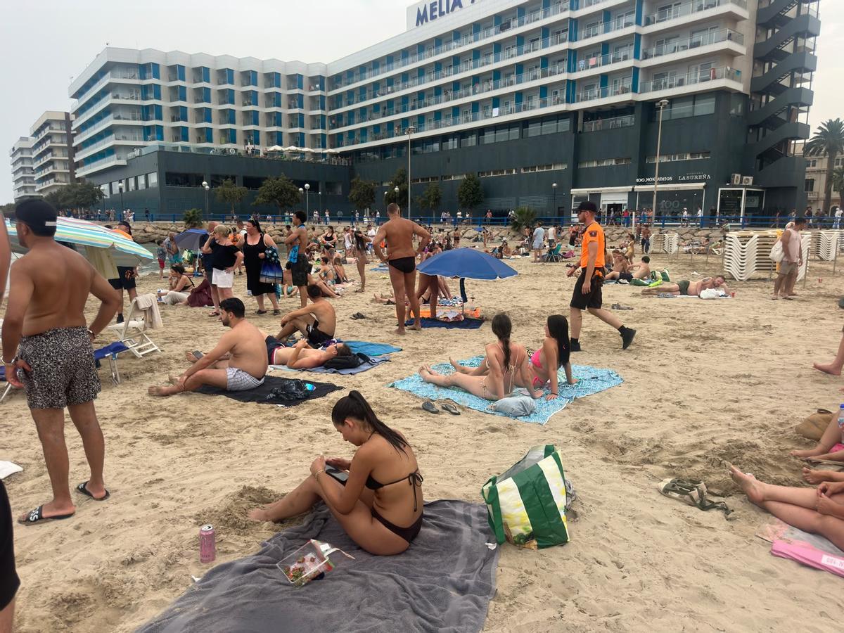 Protección Civil pidiendo a los bañistas salir del agua y retirar sombrillas en el Postiguet.