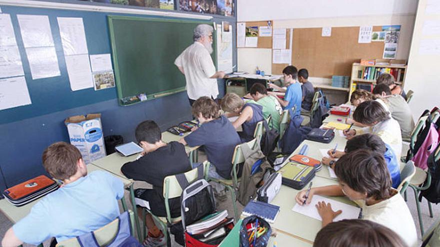 Alumnes escoltant el seu mestre durant el seu primer dia de classe.