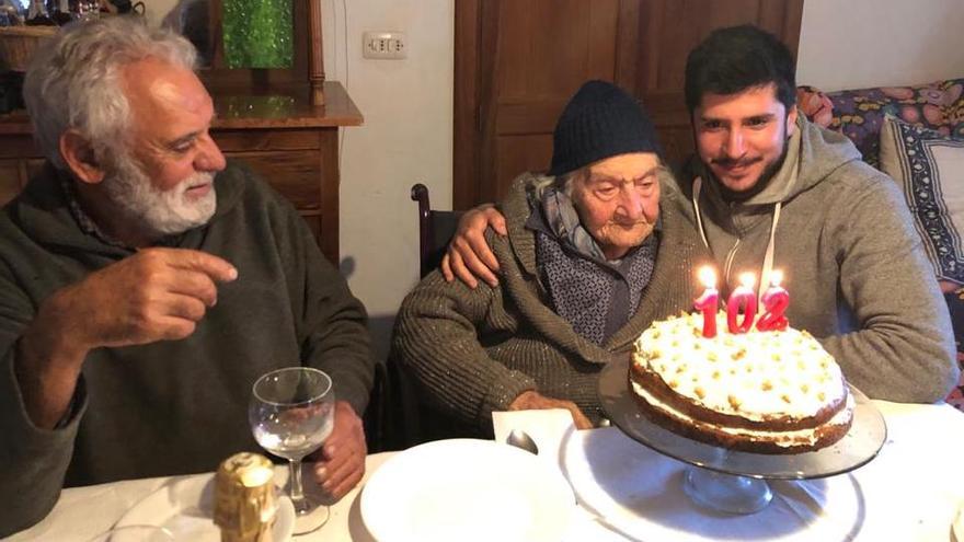 Catalina Torres sopla las velas mientras la abraza a su nieto Mariano, al lado su hijo Joan.