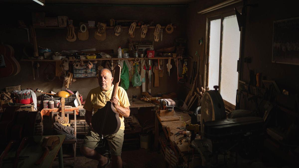 El artesano en su taller explicando como se construye un instrumento