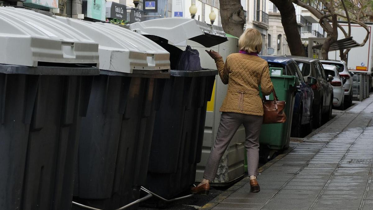 Una vecina tira la basura en un contenedor de la calle Viera y Clavijo de Las Palmas de Gran Canaria.