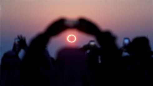 Unas personas fotografían el eclipse solar anular en una ciudad de Arabia saudita el 26 de diciembre de 2019.