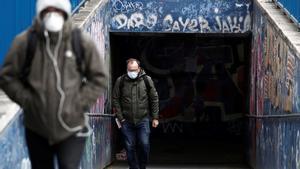 MADRID 19/03/2020.- Dos personas protegidas con mascarillas en los aledaños del hospital La Paz de Madrid este jueves durante la cuarta jornada laboral de aislamiento para frenar el avance del coronavirus. EFE/Mariscal