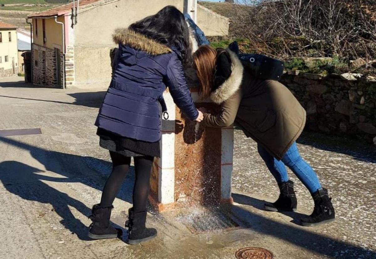 Dos residentes junto a una de las fuentes locales de Manzanal. | Ch. S.