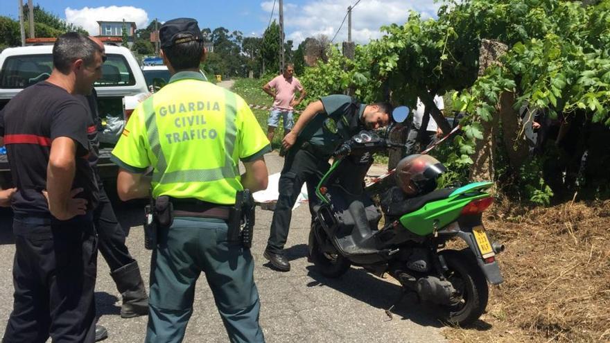 Bomberos y Guardia Civil junto al ciclomotor del fallecido. // FdV