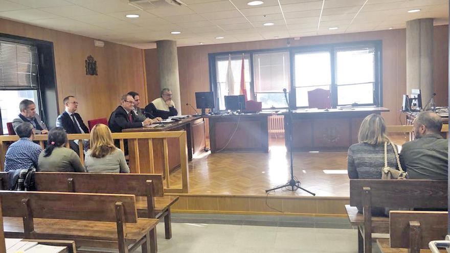 Los cinco acusados, de espaldas en el banquillo, en la vista de conformidad celebrada ayer en Vigo. // FdV