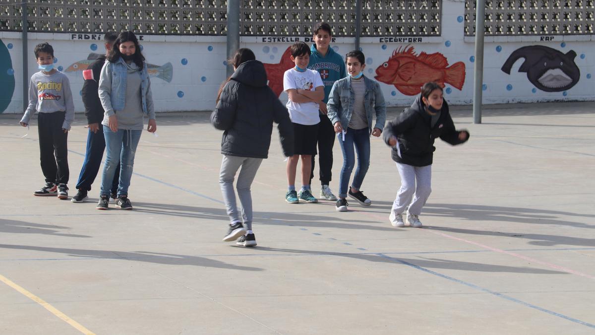 Alumnes corren al pati mentres fan relleus