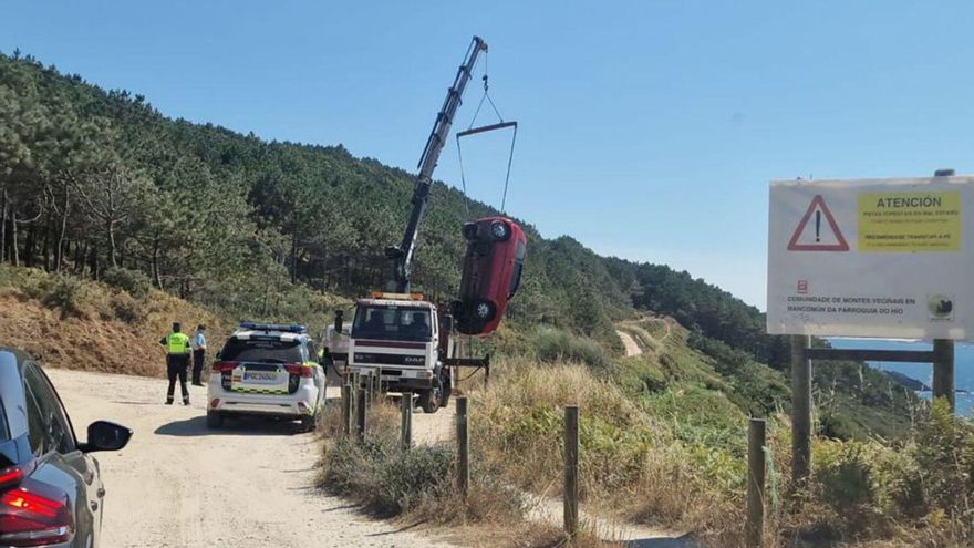 Una grúa levanta el vehículo siniestrado en Donón. | MAMP