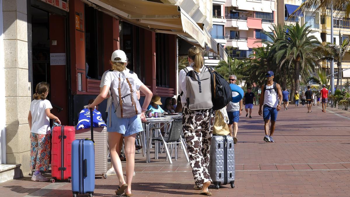 Turistas con maletas de viaje en la avenida de las canteras, en la capital grancanaria.
