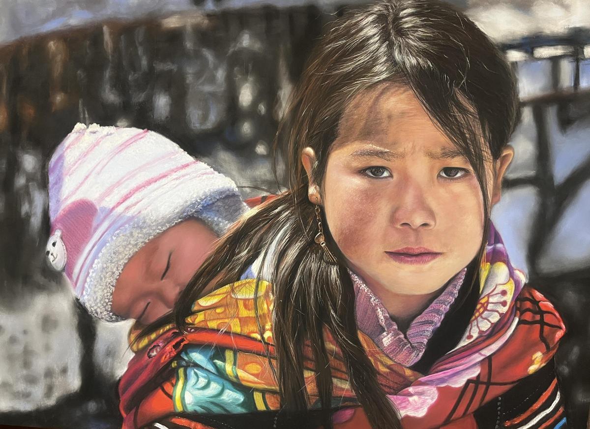 El cuadro "Infancia desamparada" retrata a una niña vietnamita obligada a hacerse cargo de su hermana pequeña