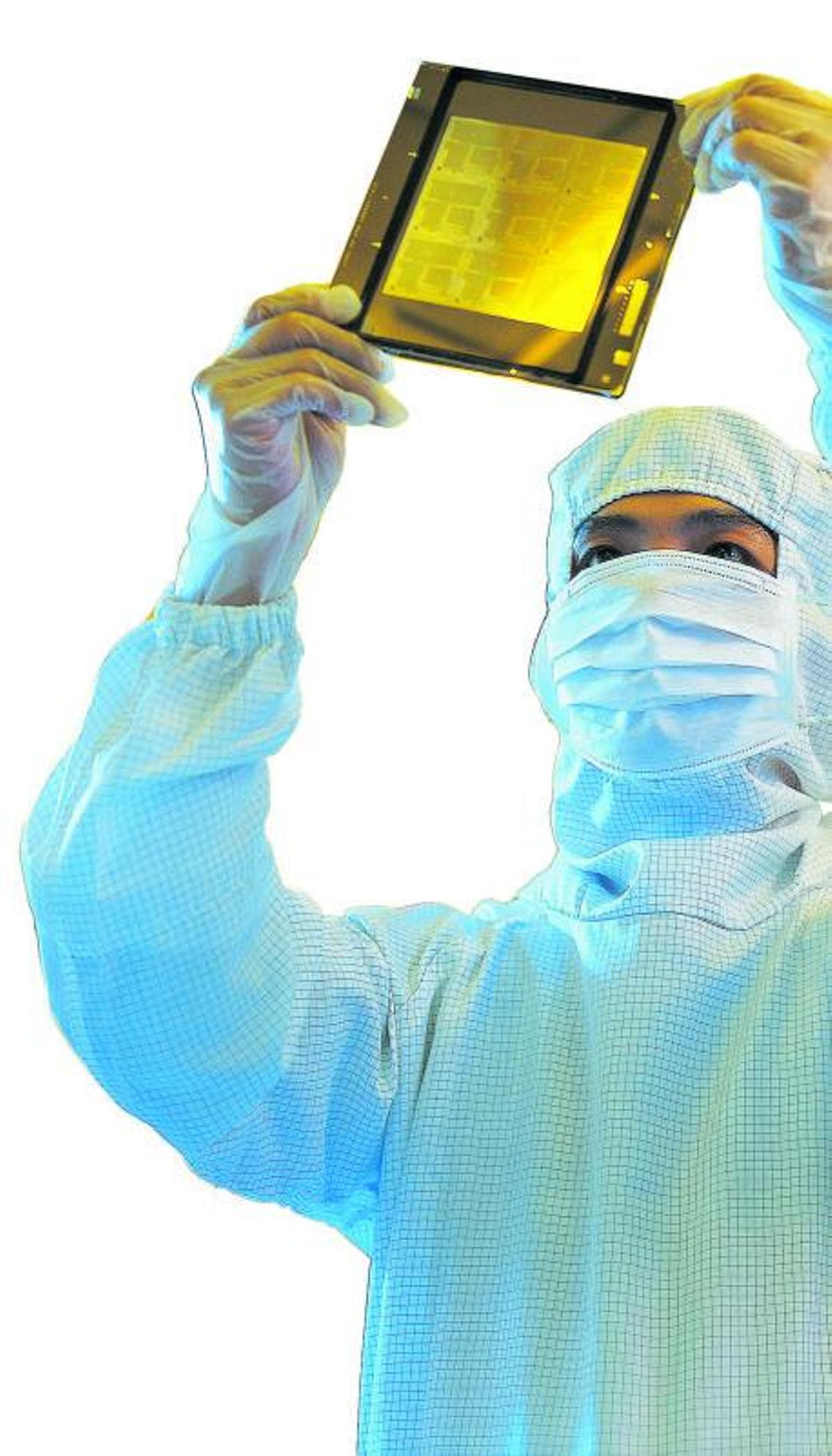 Un trabajador de TSMC  revisa una de las obleas producidas en la factoría taiwanesa| Taiwan Semiconductor Manufacturing Co. Ltd.