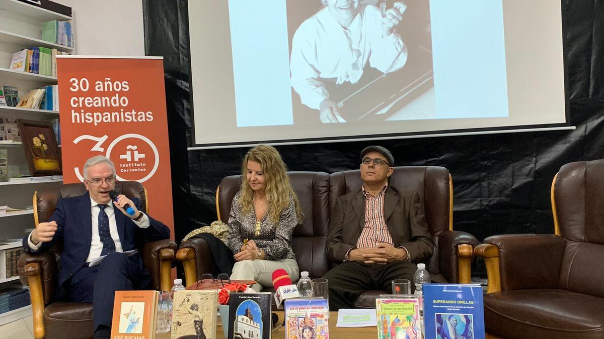 Francisco Oda Ángel, Ana Cristina Baidal y Mohamed Abrighach, durante el homenaje, con la fotografía de Concha López Sarasúa proyectada.