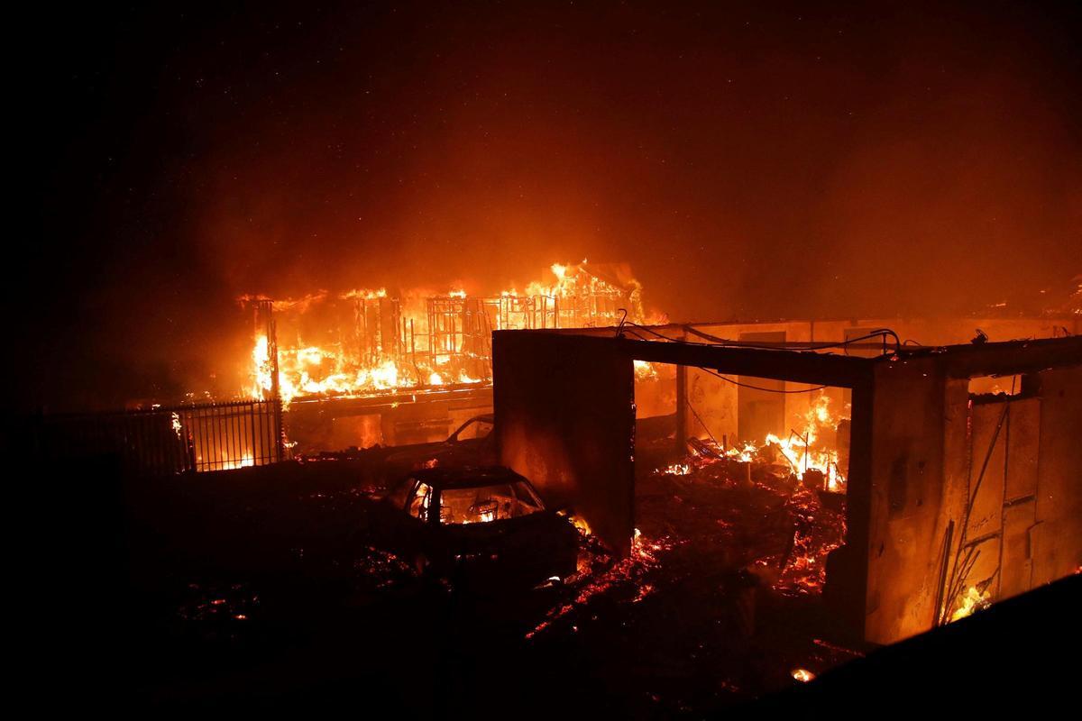 Vehículos y casas arden durante un incendio en Viña del Mar, Chile, el 2 de febrero de 2024. Una enorme nube de humo en forma de hongo se cierne sobre las zonas turísticas del centro de Chile, incluidas Viña del Mar y Valparaíso, donde estalló un incendio forestal el viernes. amenazando cientos de hogares y obligando a la evacuación de los residentes.