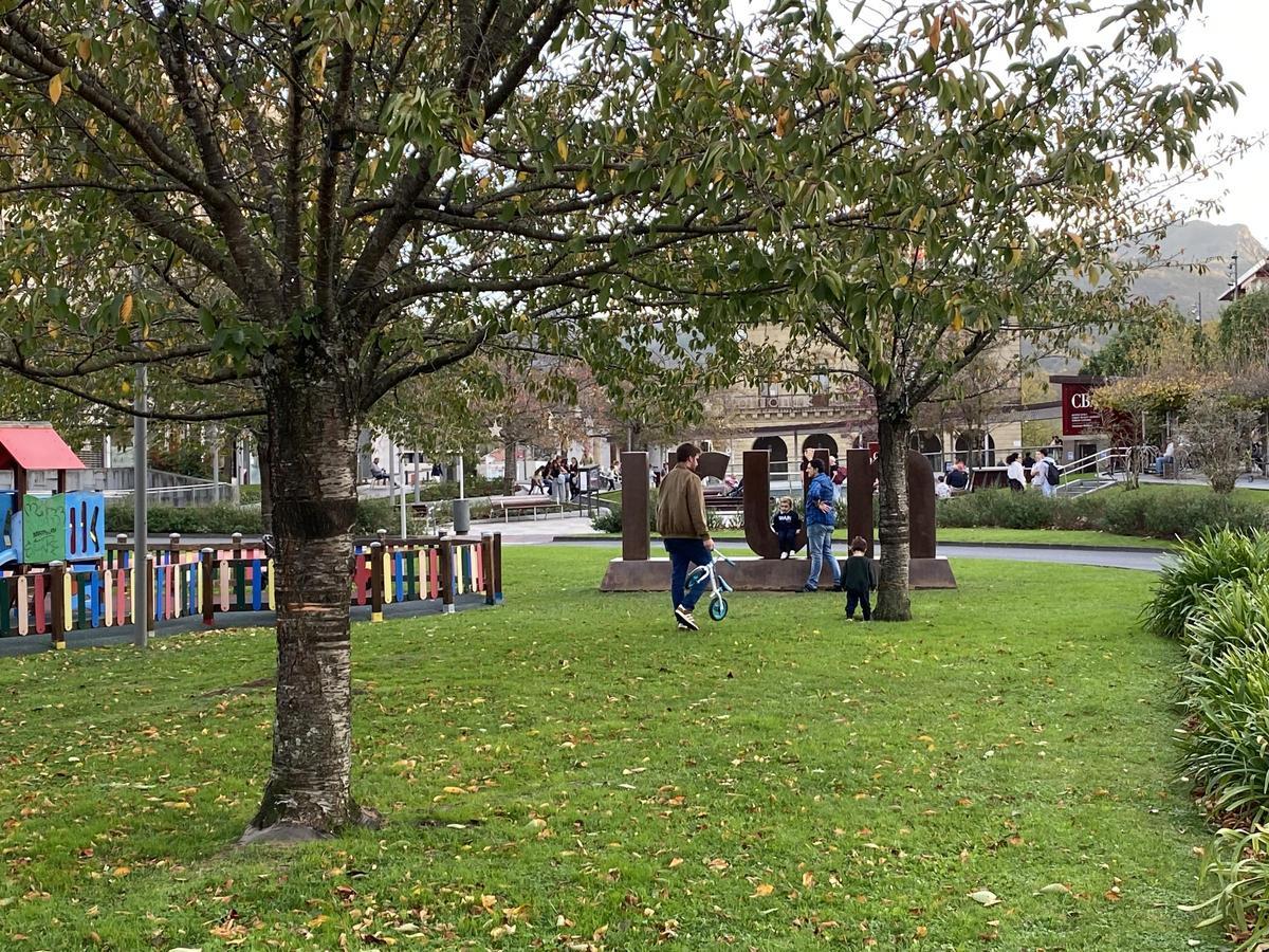 Varios padres juegan con sus hijos en una plaza del centro de Irún.