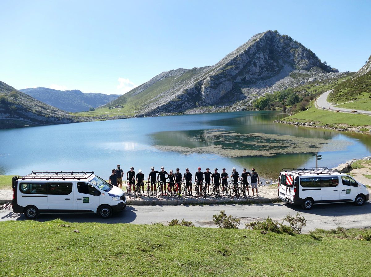 Cicloturistas tras subir a los Lagos, posan junto a las furgonetas que los recogen