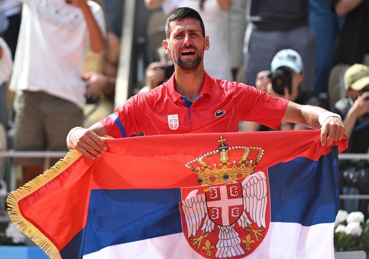 Novak Djokovic con una bandera de Serbia tras ganar el oro olímpico en París 2024.