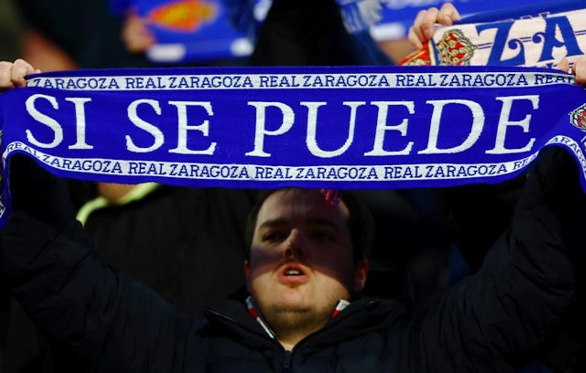 Un aficionado levanta una bufanda con la inscripción 'Sí se puede' en el Ibercaja Estadio.