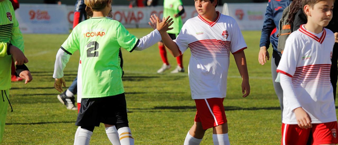 Dos jugadores de fútbol se saludan en un partido de la Copa Covap.