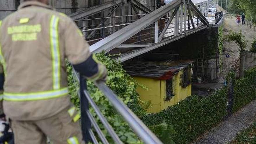 Un bombero observa la chabola tras la extinción. // Brais Lorenzo