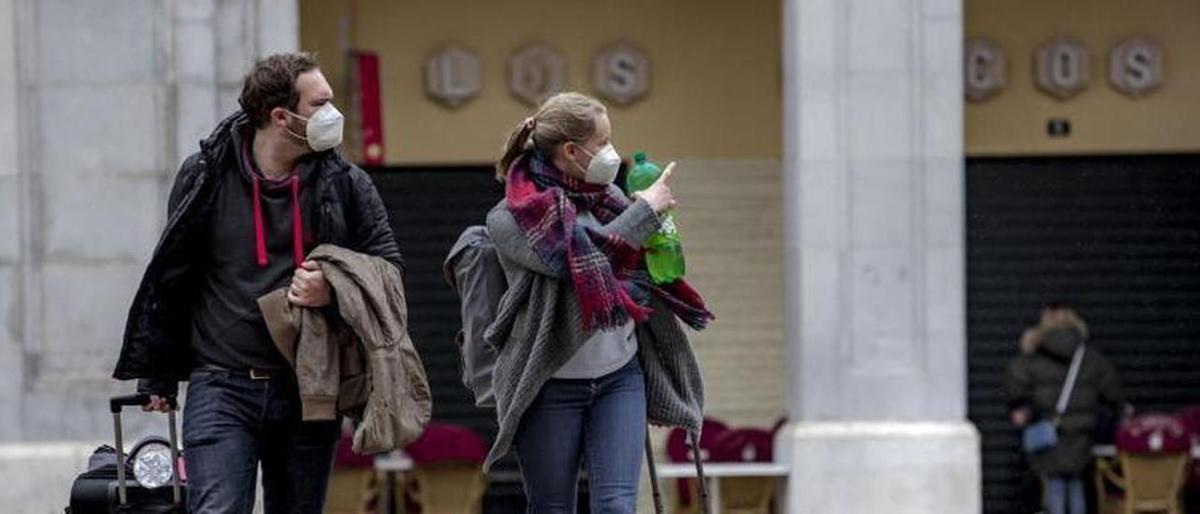 Turistas arrastrando maletas en la Plaza Major de Palma en busca de un piso turístico.