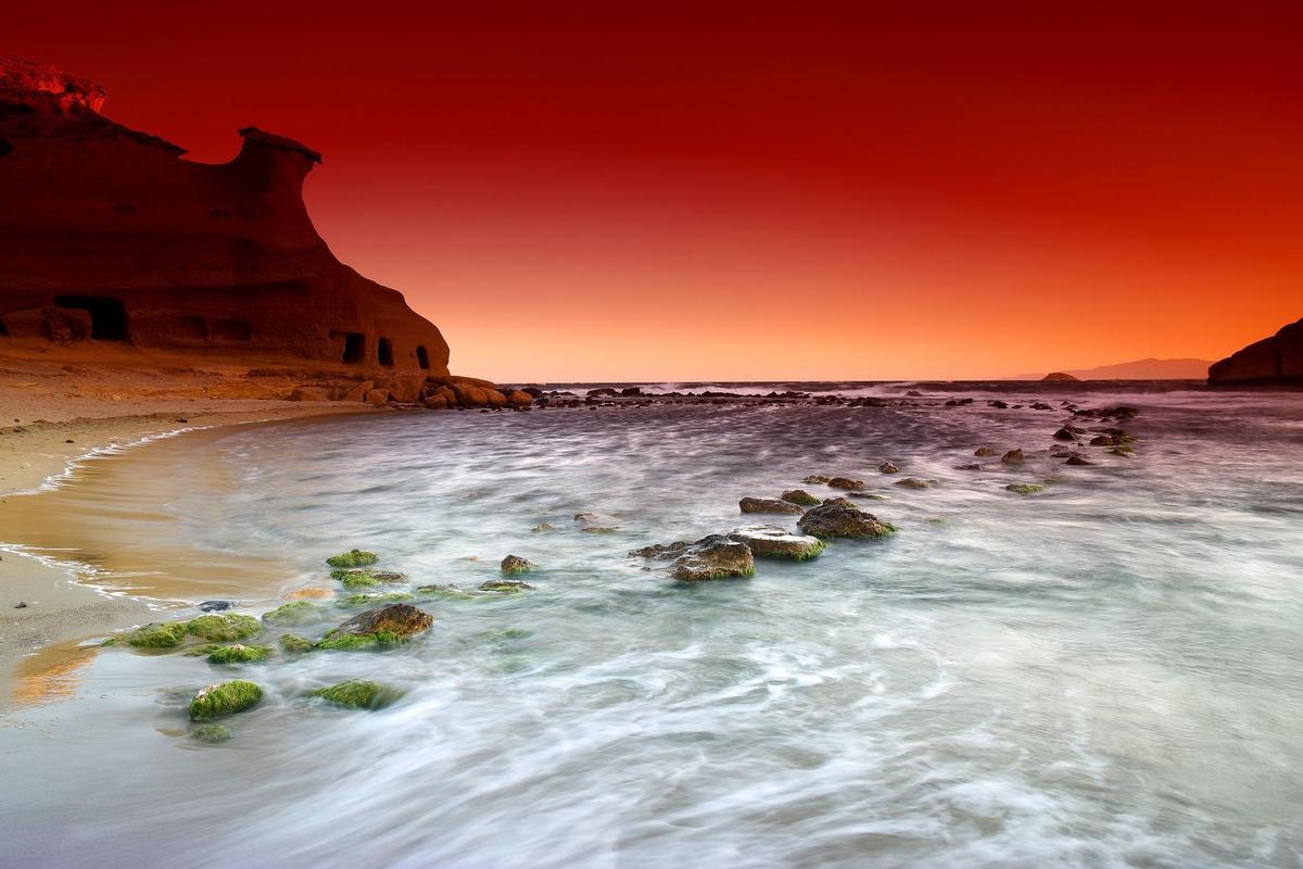 La playa murciana de los Cocedores, en el entorno que rodea a la denominada Cala Cerrada, es un espectacular paraje en el que el cielo parece teñirse de rojo, naranja o rosa, según la etapa del año.