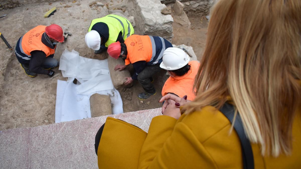 La alcaldesa Irene Navarro observando la columna romana en la excavación.