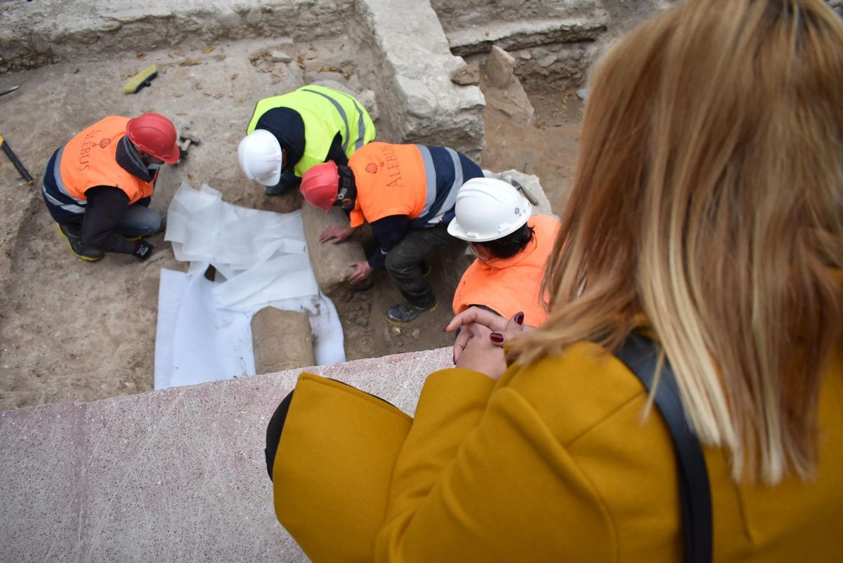 La alcaldesa Irene Navarro observando la columna romana en la excavación.