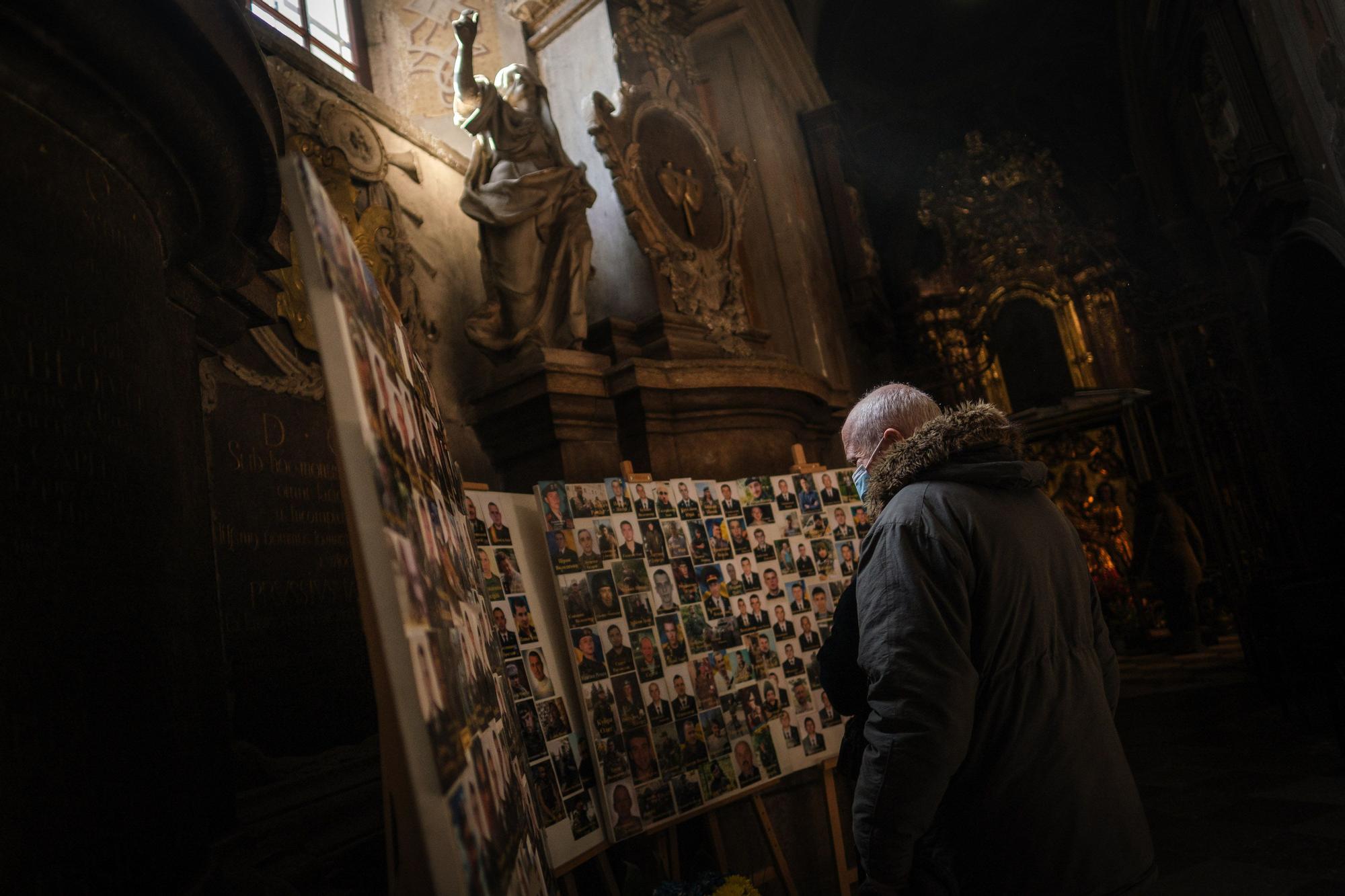 Un hombre reza por los caídos en una iglesia de Lviv