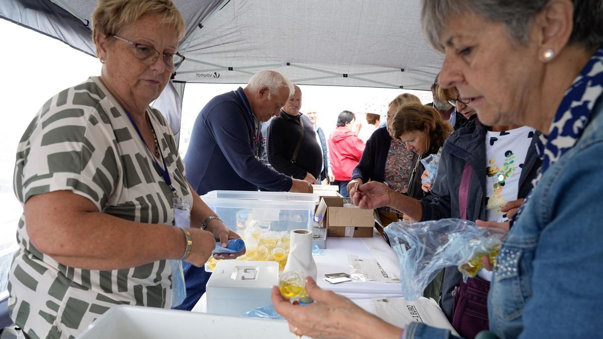 Reparto de embases con el "aceite del santo" en una anterior edición de la romería.