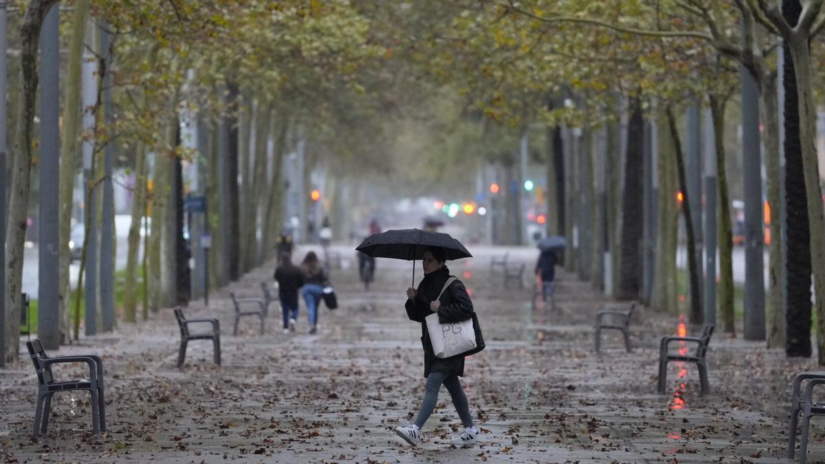 Persona caminando bajo la lluvia en Barcelona.