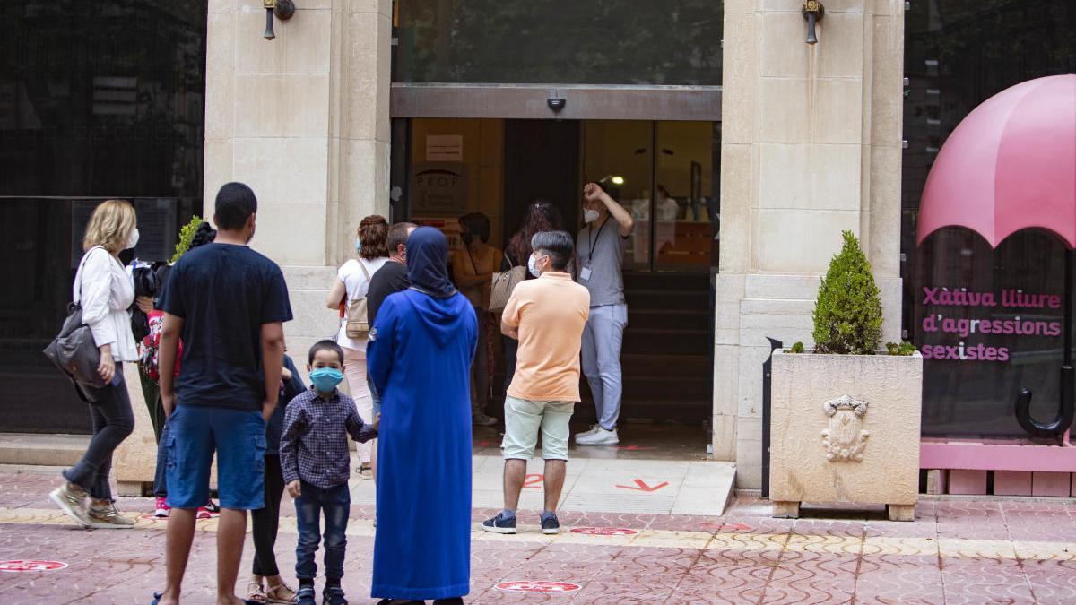 Cola de gente para realizar trámites de forma presencial en el Ayuntamiento de Xàtiva, esta mañana.