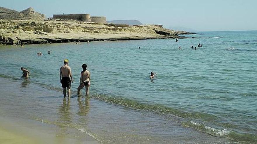 Bañistas en El Playazo; al fondo, la batería de San Ramón.