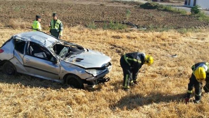 Efectivos de Bomberos y de la Guardia Civil, junto al coche siniestrado.