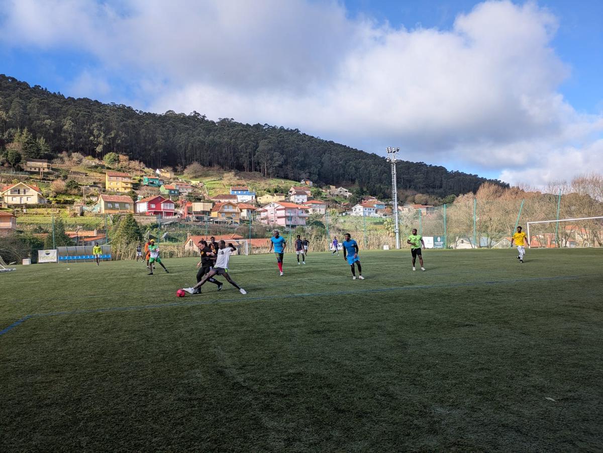 Un grupo de los refugiados que están acogidos en Bueu juegan al fútbol en el campo de A Graña, en una actividad en colaboración con el Club Deportivo Bueu.