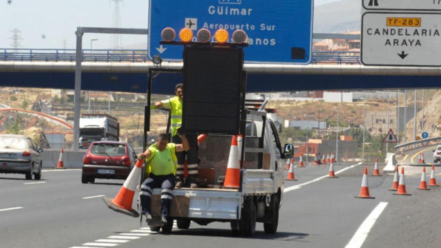Operarios de carreteras señalizan unas obras en la autopista TF-1.
