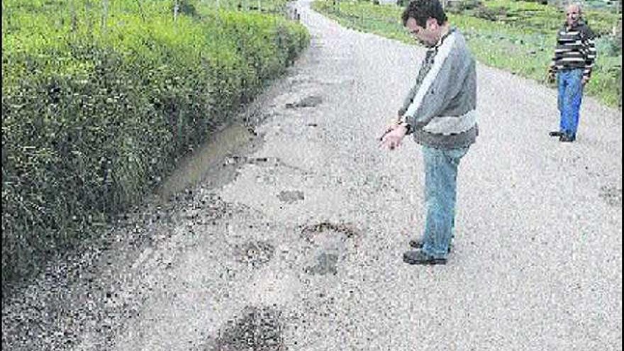 Osmel Fernández señala una zona de la LL-6  especialmente maltratada, en presencia de José Antonio Sánchez.