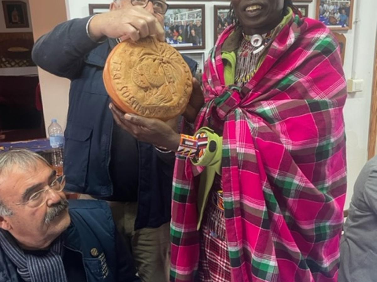 El guerrero masai recibiendo el tradicional perol de arroz que se llevan como recuerdo los invitados