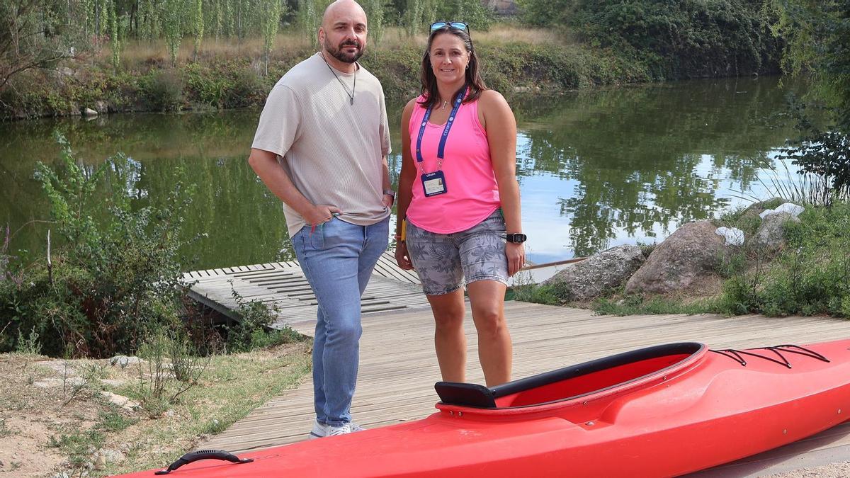 El concejal Manuel Alonso y la representante de la empreas que dirige la actividad, Cristina García, junto a una de las piraguas.