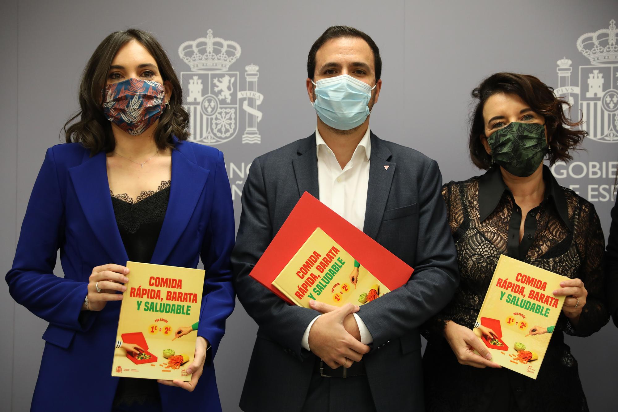 Alberto Garzón, ministro de Consumo (centro de la imagen), acompañado por Marian García (izquierda) y la chef María José San Román (derecha), autoras del recetario 'Comida rápida, barata y saludable', publicada por el Ministerio de Consumo el 10 de noviembre.