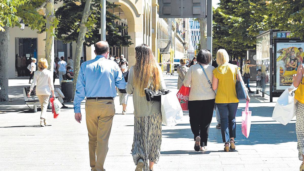 Dos parejas pasean con bolsas de compra por el paseo de la Independencia de Zaragoza