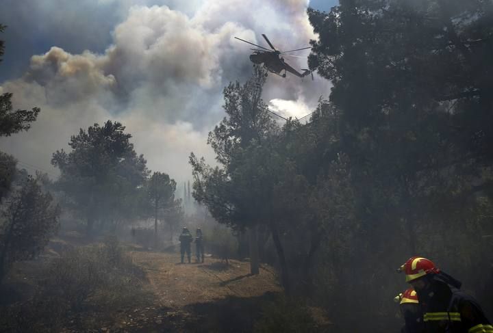 Decenas de ciudadanos de Atenas se han visto obligados a abandonar sus hogares ante la proximidad de un incendio forestal potenciado por los fuertes vientos registrados en la capital griega y que amenaza con alcanzar zonas habitadas de la urbe