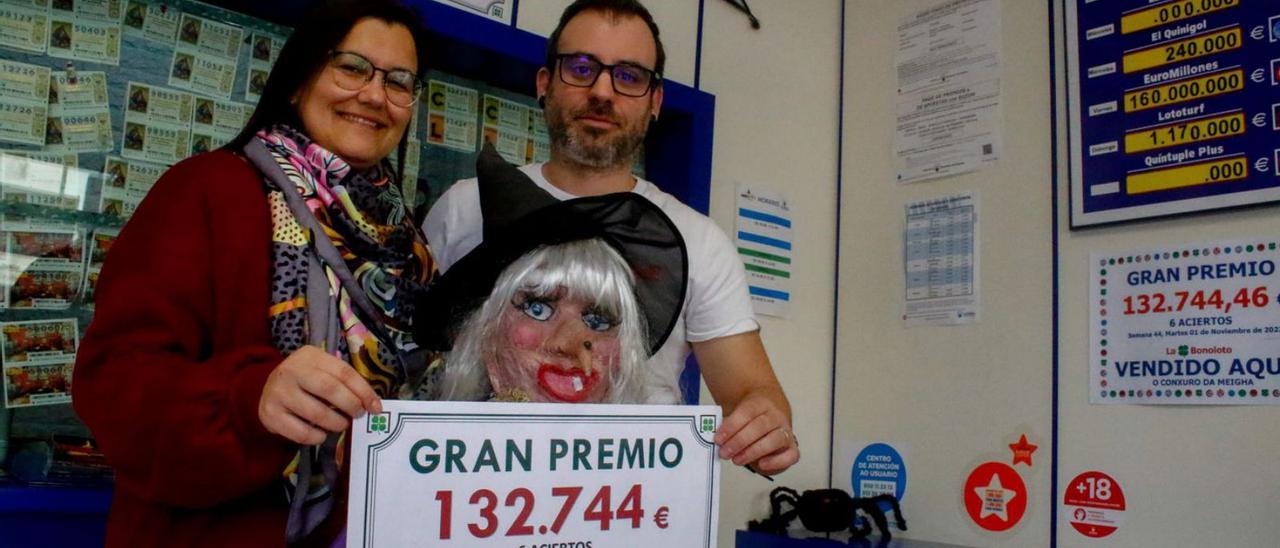 Jéssica Allo y Rubén Rodríguez, ayer, con el cartel del premio y la “meigha” de la casa. |   // IÑAKI ABELLA