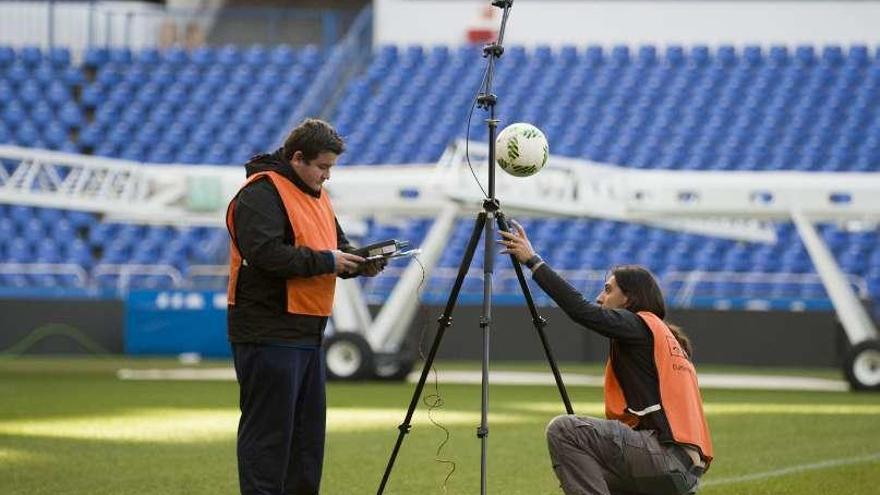 Los técnicos de la Liga revisando el césped del estadio.